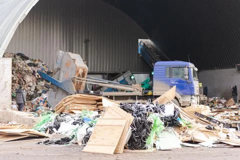 A pile of construction debris in front of a garbage truck Stock Photos