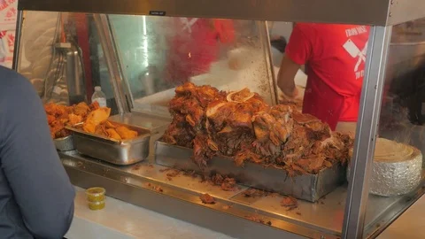 Pile of cooked meat in a hot case at a busy taco eatery. Video stock 82827774