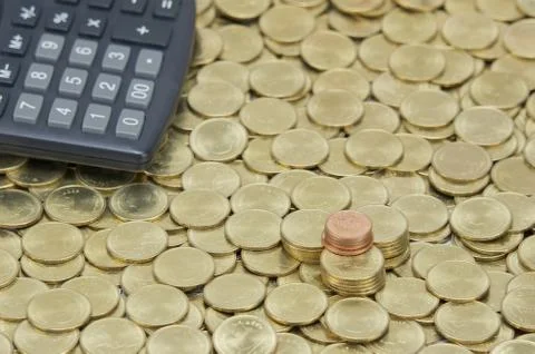 Pile of copper coins with calculator on stack gold coins Foto stock