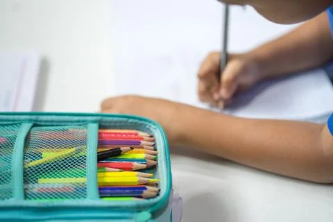 A pile of crayons on a student's drawing table. Stock Photos