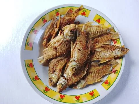 Pile of Crispy Fried Fish on Yellow Floral Plate Indonesian Food Stock Photos