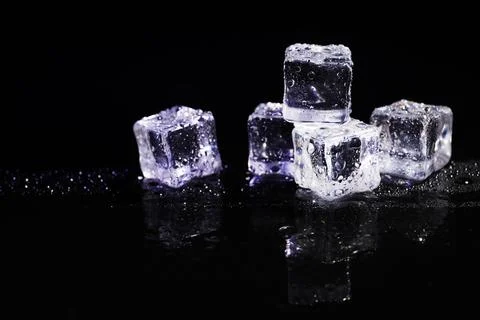Pile of crystal clear ice cubes on black background Foto stock
