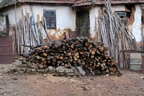 Pile of cut tree in front of old house Stock Photos