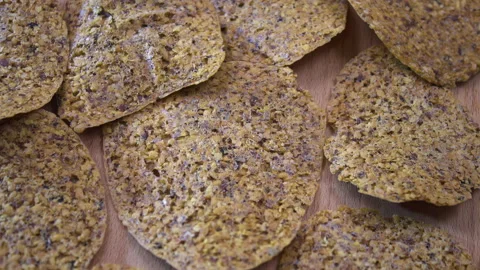Pile of dehydrated fruit and seed crisps rotating on wooden surface, top view Vídeo Stock 345611087