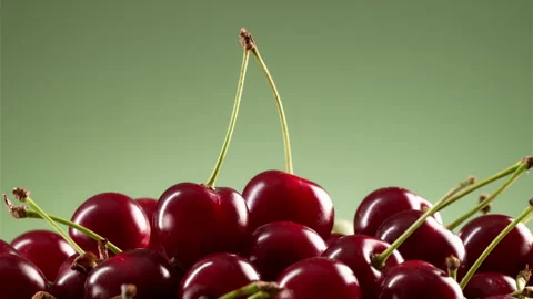 A pile of delicious cherries on a green gradient background. Vídeos de archivo 314179353