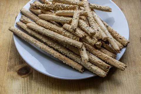 Pile of delicious classic crispy bread sticks (grissini) on a white plate Stock Photos