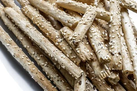 Pile of delicious classic crispy bread sticks (grissini) on a white plate Stock Photos