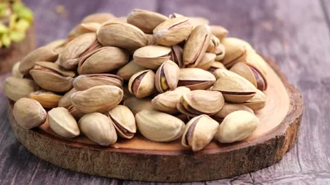 Pile of delicious pistachios resting on rustic wooden surface close-up footag Stock-Footage 332544717