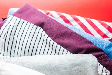 Pile of different clothes on red background.  Stock Photos