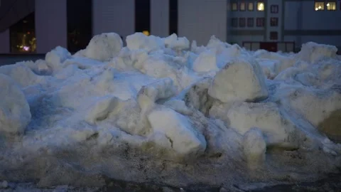 Pile of dirty melting snow chunks in a city at evening Stock Footage 332729125