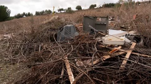 Pile of discarded electronics and branches at a field Stock Photos