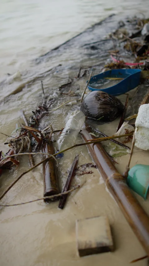 Pile of discarded plastic bottles and garbage scattered across a sandy beach Stock Footage 344604826