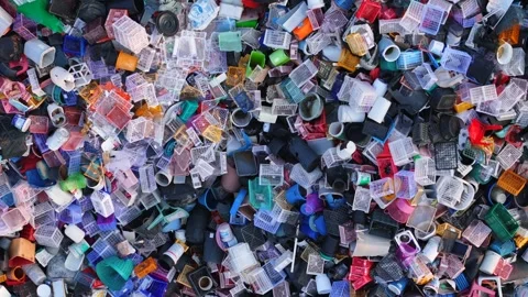 Pile of discarded plastic containers and household items in an open dump Stock Footage 310932518