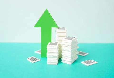 A pile of documents and papers and a green arrow pointing up. Increased bur.. Stock Photos