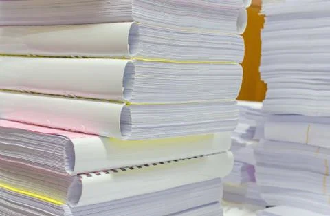 Pile of documents on desk stack up high waiting to be managed Stock Photos