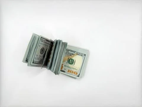 A pile of dollars lies on a flat surface in a folded position on the left, an Stock Photos