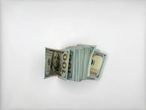A pile of dollars lies on a flat surface in a folded position in the center of Stock Photos