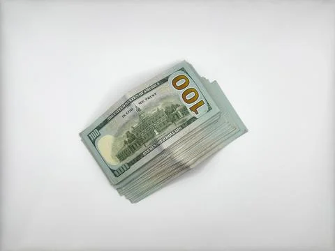 A pile of dollars lies on a flat surface, laid out face down in the center of Stock Photos