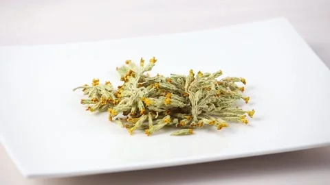 Pile of dried cowslips blossoms, Primula veris on plate for herbal medicine. Stock Footage 148091393