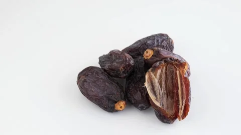 Pile of dried dates fruit isolated on white. Slow panning shot Stock Footage 263830742