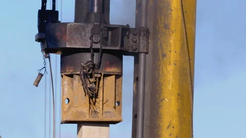 Pile driving machine with rumble and smoke drives piles deep into the ground Stock Footage 147632147