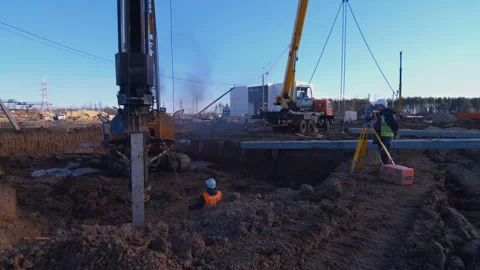 Pile driving machine with rumble and smoke drives piles deep into the ground Stock Footage 161952388