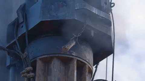Pile driving machine with rumble and smoke drives piles deep into the ground Stock Footage 161953444
