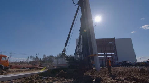 Pile driving machine with rumble and smoke drives piles deep into the ground Stock Footage 161956325