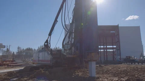 Pile driving machine with rumble and smoke drives piles deep into the ground Stock Footage 161956795