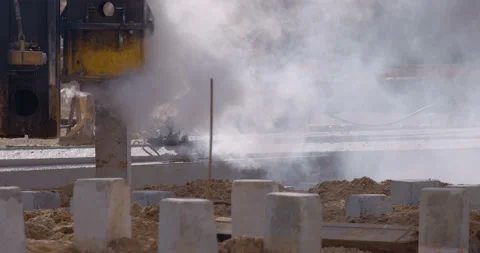 Pile driving machine with rumble and smoke drives piles deep into the ground Stock Footage 161957752