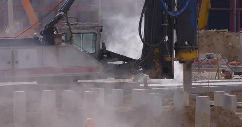 Pile driving machine with rumble and smoke drives piles deep into the ground Stock Footage 161957911