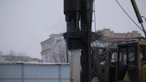 Pile driving rig installing concrete foundation pile in winter Stock Footage 327041433