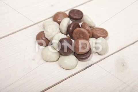 Pile of Dutch candy chocolate pepernoten on white wooden background Stock Photos
