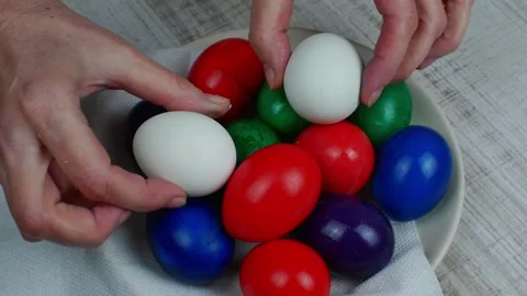 Pile of Easter eggs of different colors are stacked on a white plate. Easter Stock Footage 242976795