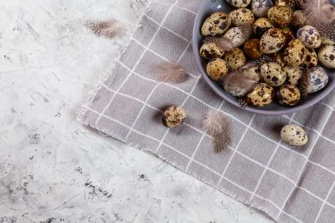 Pile of Easter quail eggs on gray fabric rag on concrete background 스톡 사진