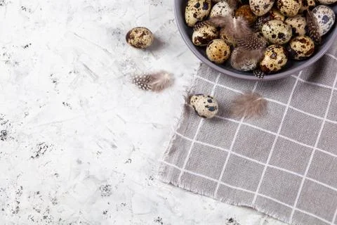 Pile of Easter quail eggs on gray fabric rag on concrete background 스톡 사진