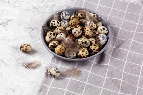 Pile of Easter quail eggs on gray fabric rag on concrete background 스톡 사진