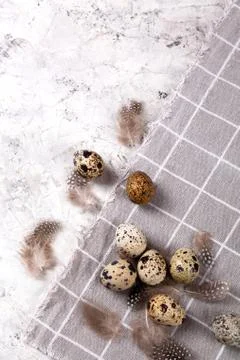 Pile of Easter quail eggs on gray fabric rag on concrete background 스톡 사진