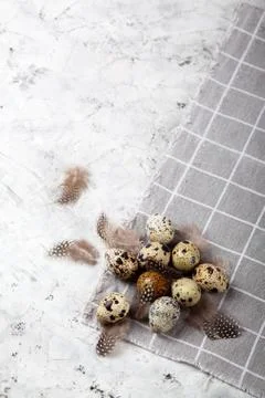 Pile of Easter quail eggs on gray fabric rag on concrete background Stock Photos