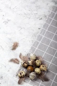 Pile of Easter quail eggs on gray fabric rag on concrete background Stock Photos