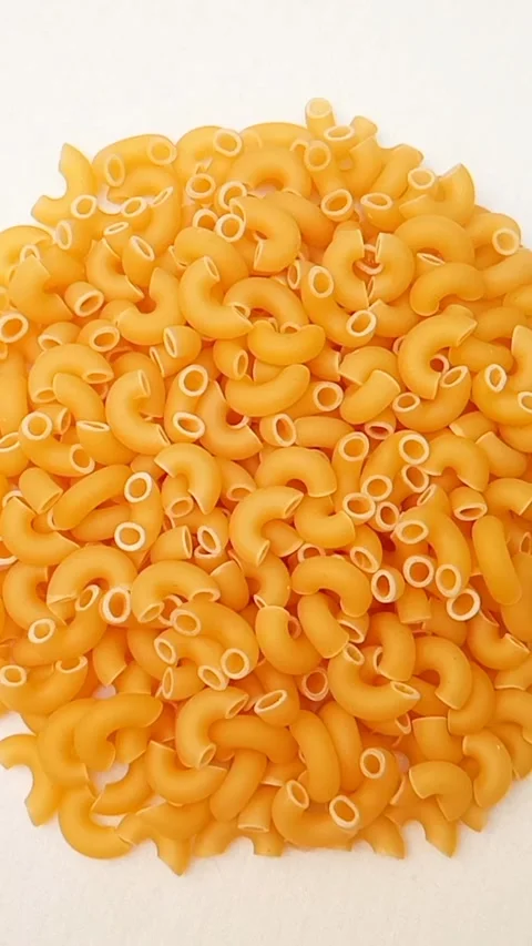 A Pile Of Elbow Macaroni Pasta Rotating on White Background, Uncooked Elbow.. Vidéo 334368040