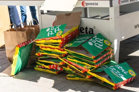 Pile of empty pizza boxes creates post-party packaging waste in a park Fotos Stock