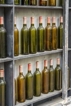 Pile of empty red wine bottles on display window outdoors Stockfoto's