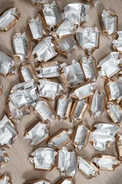 Pile of empty silver-gold candy wrappers. Top view. Stock Photos