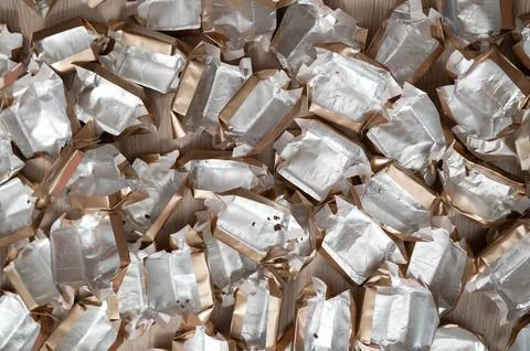 Pile of empty silver-gold candy wrappers. Top view. Stock Photos