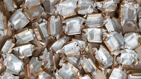 Pile of empty silver-gold candy wrappers. Top view. Stock Photos