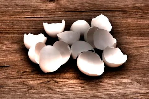 A pile of empty  white egg shells lying on a wooden board surface Stock Photos