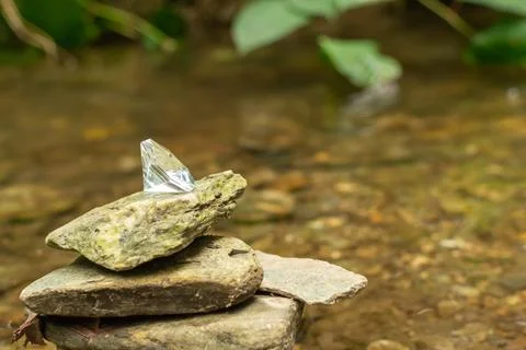 Pile of flat, sharp rocks in a forest with a precious diamond on top of them Stock Photos
