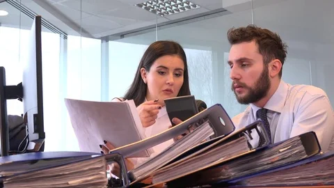 Pile of folders documents accounting team use calculator sales profits calculate Stock Footage 84318582