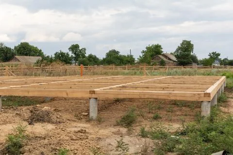 On pile foundations support the floor of a frame house Foto stock